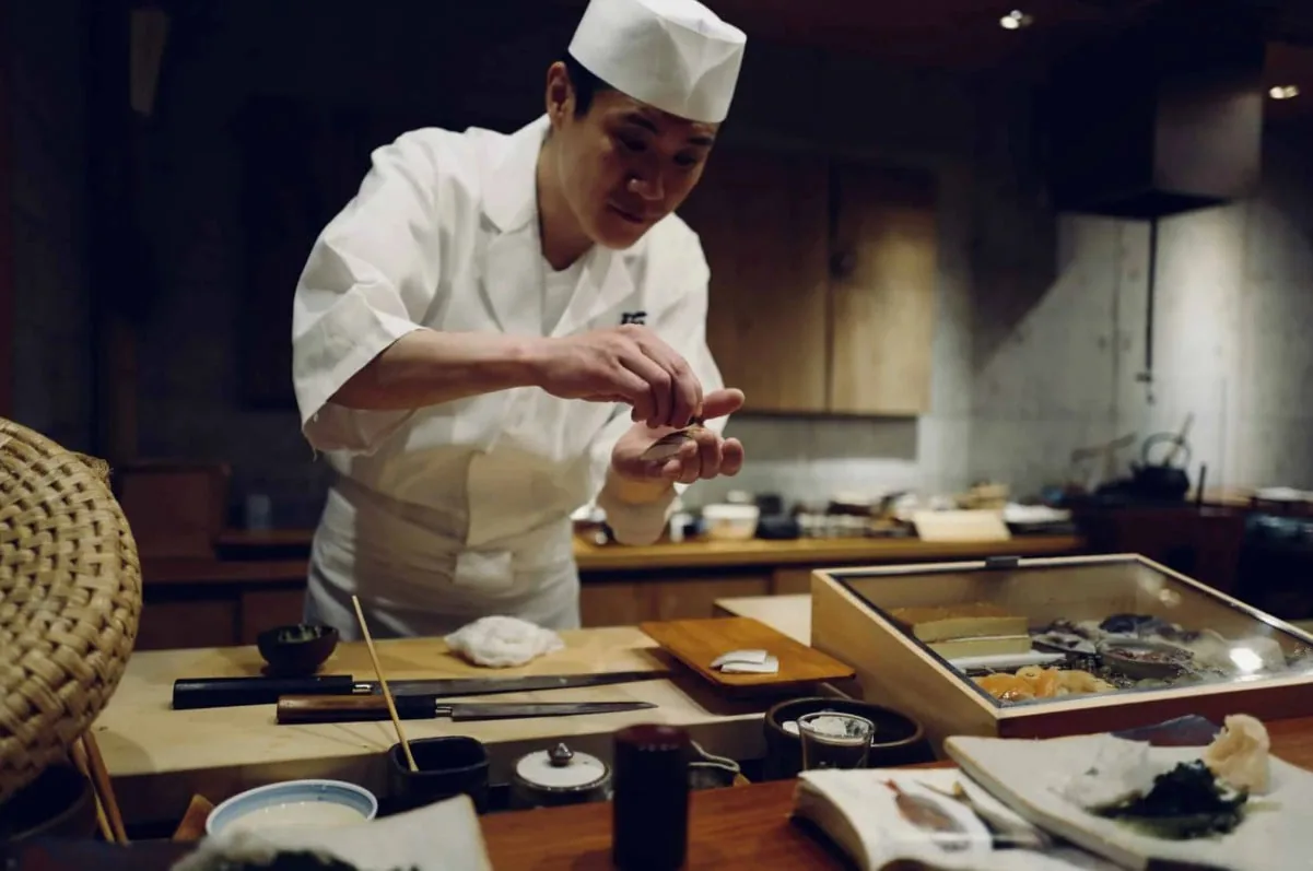 厨房のカウンターで盛り付けをする料理人
